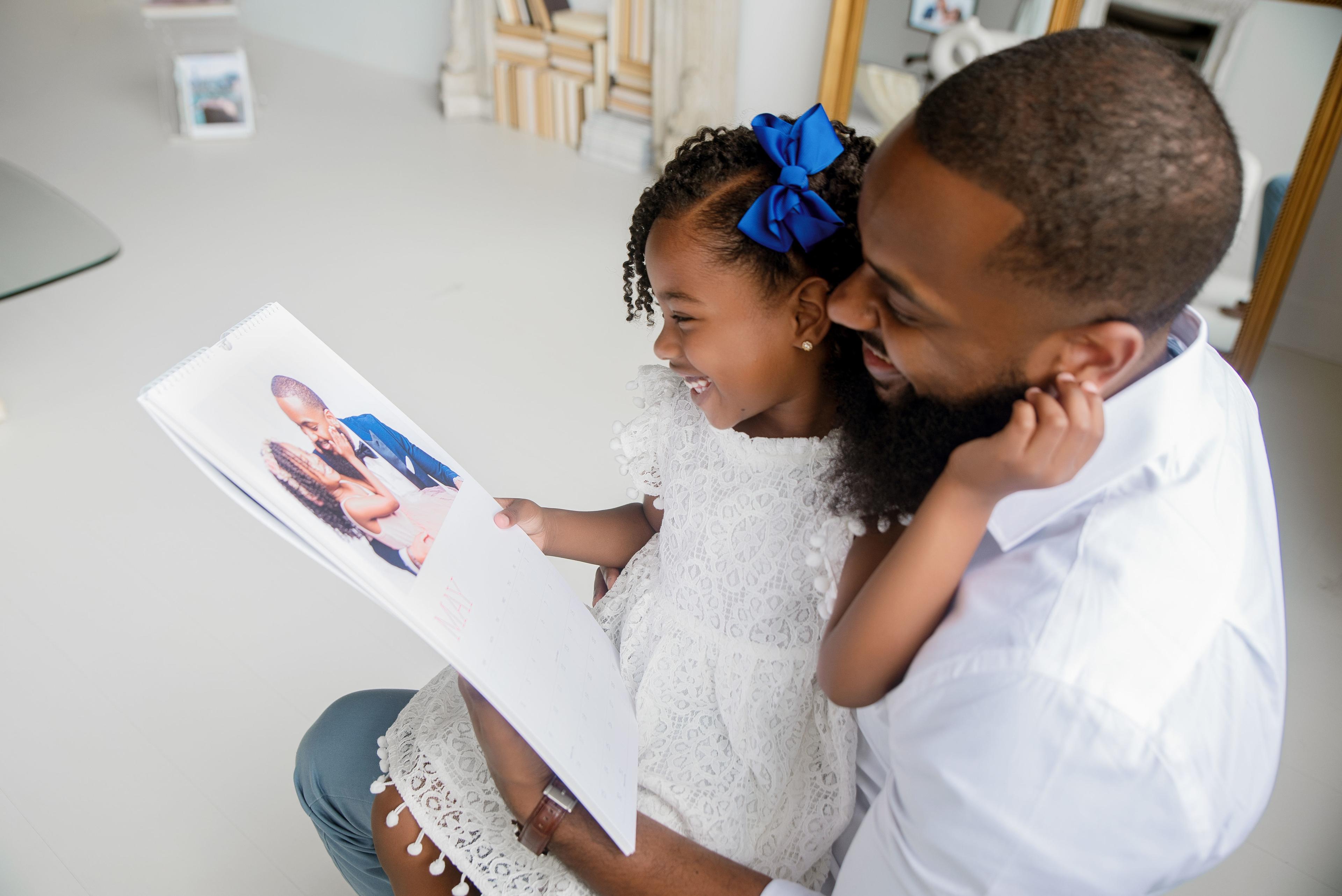 Young girl and dad holding wall calendar